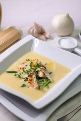 Creamy potato soup with grilled chicken breast, parmesan shavings and arugula