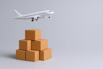 Global Logistics Concept: Airplane Flying Over Stack of Cardboard Boxes, Representing Worldwide Shipping and Delivery