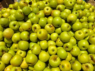 Organic green apples stacked at a farm market. Fresh, crisp, and vibrant—ideal for themes of healthy eating, natural produce, and seasonal harvest