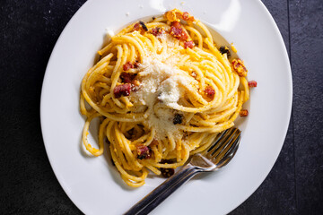 close up of spaghetti carbonara in white bowl