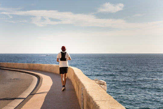 Coureur en tenue de sport sur la corniche de Marseille avec vue mer, vue de dos, Marseille, Sud de la France