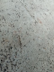 Close-up of rough old concrete wall texture, weathered and worn by time, showcasing cracks, uneven surface, and natural aging patterns.