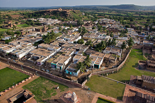 Aerial view of houses with white rooftops nestled below a hill topped with a fort, a blend of urban and rural landscapes., Gandikota, Andhra Pradesh, India.