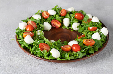 Christmas wreath salad of arugula, cherry tomatoes and mini mozzarella