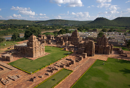 Aerial view of the Durga temple complex, with sandstone structures standing in sharp contrast to the bright green grass, Aihole, Karnataka, India.