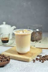 Ice coffee in a plastic cup with brown sugar and ice cubes and beans
