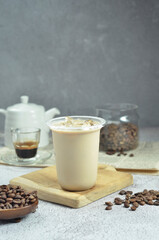 Ice coffee in a plastic cup with brown sugar and ice cubes and beans