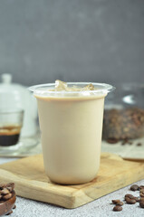 Ice coffee in a plastic cup with brown sugar and ice cubes and beans