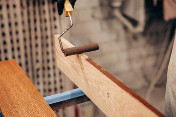 Applying Wood Stain with Roller in Workshop