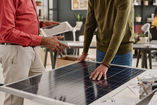 Crop shot of unrecognizable male specialists developing new solar panel model at work in office