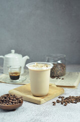 Ice coffee in a plastic cup with brown sugar and ice cubes and beans