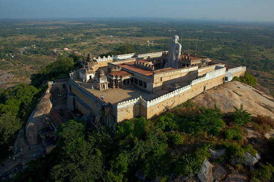 Aerial view of Shravanabelagola, Karnataka, India, where the colossal Gomateshwara statue stands atop the rocky hill, a beacon against the verdant landscape, evoking a sense of awe and serenity.