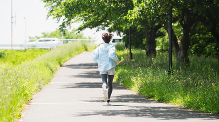 Obraz premium ランニングをする若い女性 スポーツイメージ