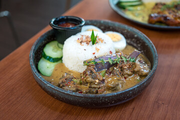 Steamed coconut rice with braised beef brisket on a plate. Ready to eat Asian food.