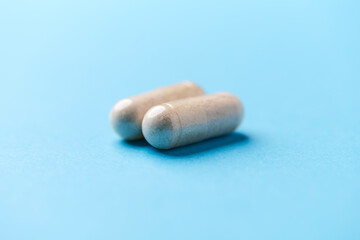Creatine capsules on paper background. Soft focus. Close up. Copy space.	