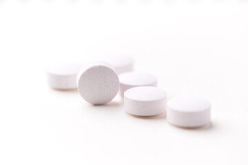 Creatine tablets on paper background. Soft focus. Close up. Copy space	