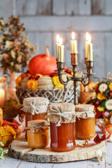 Glass jars with pumpkin preserves on the table.