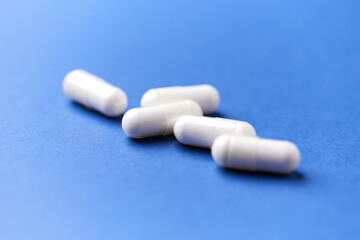 Creatine capsules on paper background. Soft focus. Close up. Copy space.	