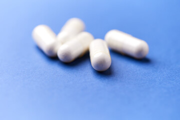 Creatine capsules on paper background. Soft focus. Close up. Copy space.	