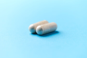 Creatine capsules on paper background. Soft focus. Close up. Copy space.	