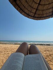 Relaxing on the beach with a book on a sunny day