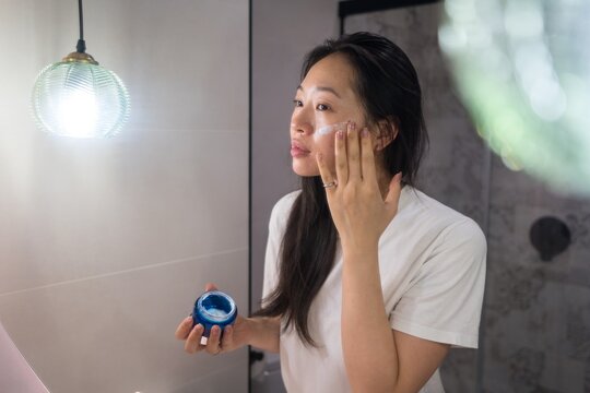Woman applying skincare product in morning routine