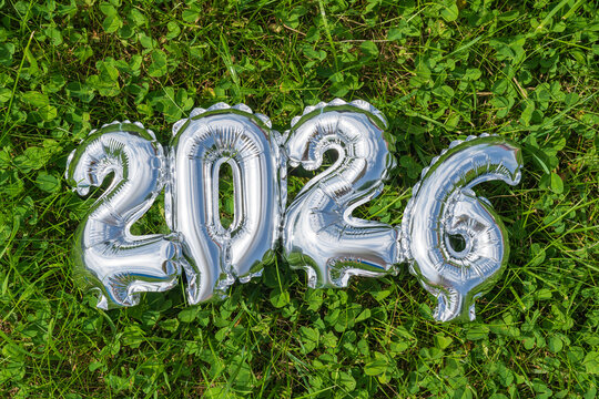 Silver balloons display 2026 on green grass background