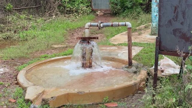 wide shot of groundwater rising to the surface and flows out without the need for a pump