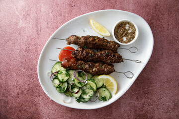 Traditional lamb kebab with cucumber salad