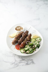 Traditional lamb kebab with cucumber salad