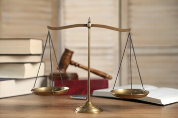 Golden scales of justice, gavel and books on wooden table