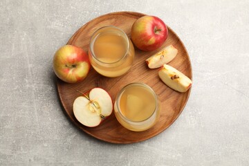 Tasty compot in glasses and fresh apples on grey table, top view