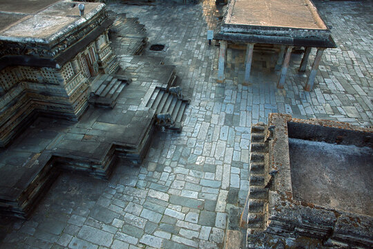 Aerial view of the intricate stone architecture and weathered textures of the Chennakesava Temple complex, reflecting history and artistry, Belur, Karnataka, India.