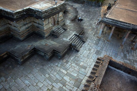 Aerial view of intricate stone carvings adorn ancient temples, their weathered surfaces whispering tales of bygone eras, Belur, Karnataka, India.