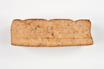A longitudinally cut piece of smoked tofu is placed on a white background, revealing its inner, grainy texture