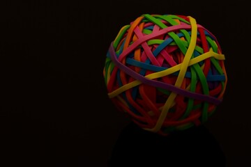 Colorful Rubber Band Ball with Reflection on a Dark Surface