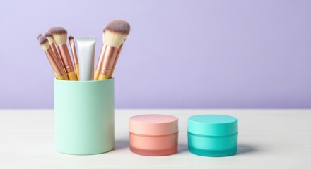 Fototapeta premium Makeup brushes and skincare creams in pastel containers on a white surface with a light purple background