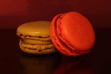 Close-Up of Colorful Macarons on a Reflective Surface With Warm Lighting