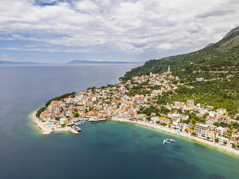 Aerial view of the coastal town nestled between the turquoise Adriatic Sea and the lush green mountains, Igrane, Split-Dalmatia County, Croatia.