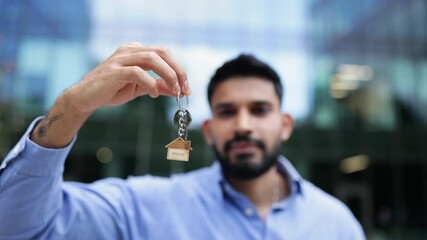A man holding a house key, symbolizing homeownership and real estate. - Powered by Adobe