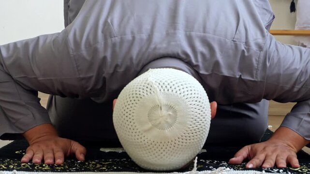 Close Up Of Muslim Man Performing Sujud And Final Movement Of Salah, The Tashahhud While Sitting On Prayer Mat