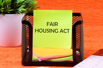 Business concept. Text fair housing act on a sticker in a stand on an orange background