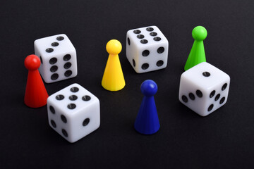 Colorful board game figures and dice isolated on black background