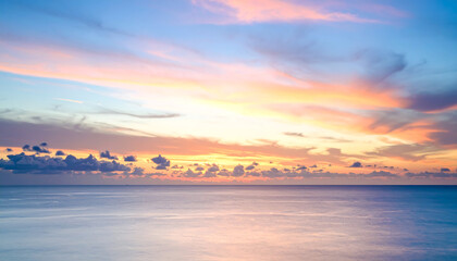 Obraz premium Serene Sunset over Calm Ocean with Pastel Hues.