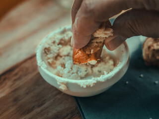 a closeup of a person eating a piece of cheese with a pretzel