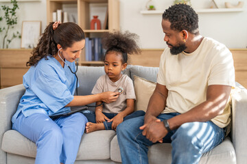 Doctor using stethoscope for medical checkup, listening to heartbeat and lungs of african child,...