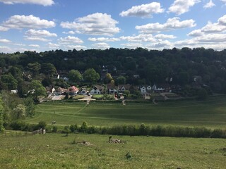 Obraz premium English Countryside Village with Green Fields and Blue Sky