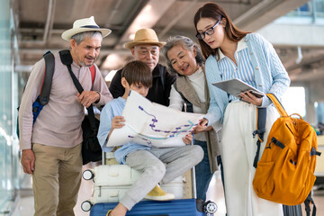 Naklejka premium Asian multigenerational family at airport traveling with kids and grandparents, joyful moments of vacation, family holiday trip with luggage before flight, tour, friendly airline, hotel for families