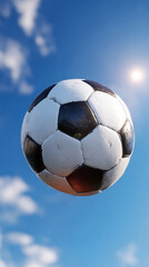 Fototapeta premium Soccer Ball in Mid Air Against Blue Sky