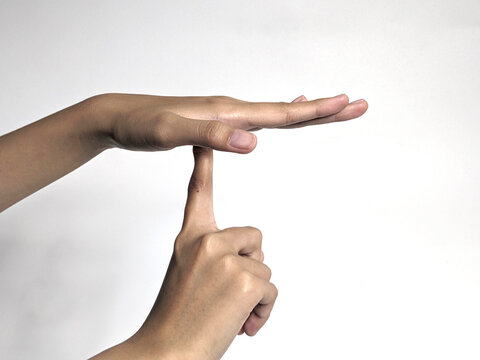 A person's hands forming a T shape gesture against a plain white background symbolizing a timeout or break